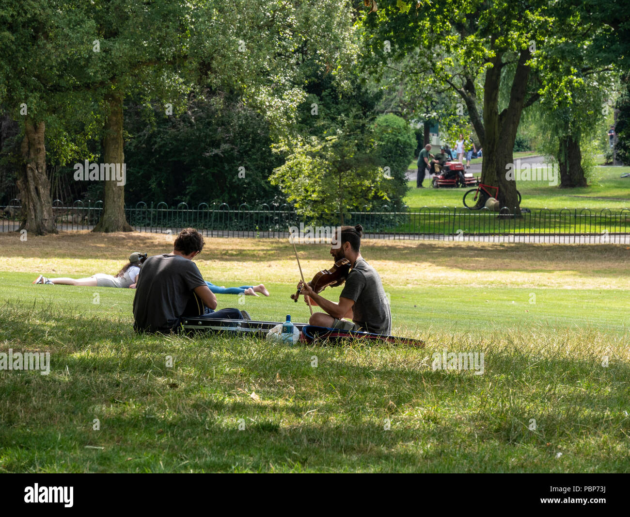 Two musicians playing outdoors in Botanic Gardens, Belfast on a sunny summer day Stock Photo
