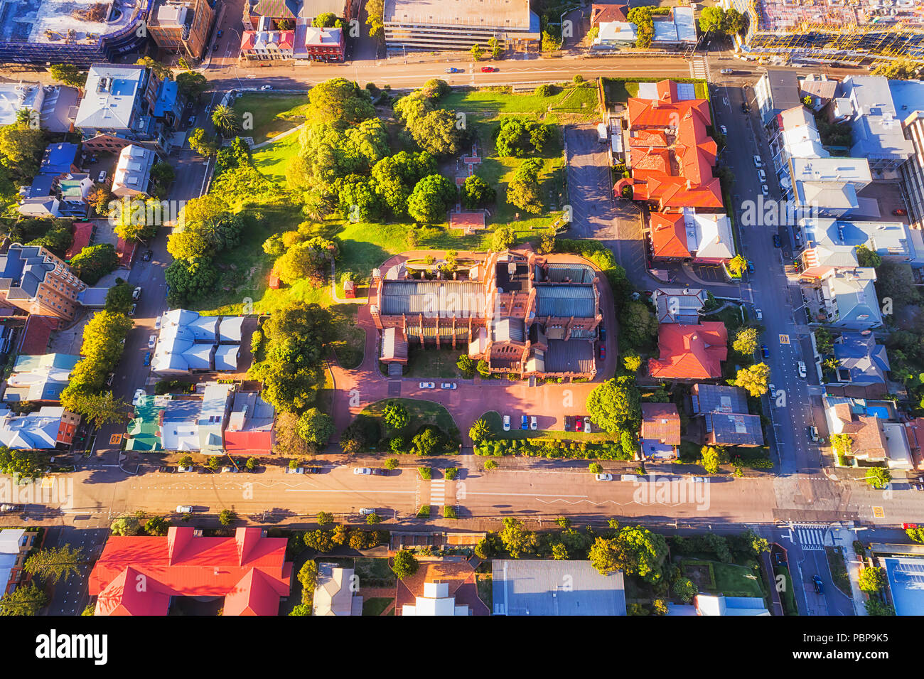 Local architectural historic landmark in modern city Newcastle of Australia. Aerial overhead view down to Cathedral site, roof and local park surround Stock Photo