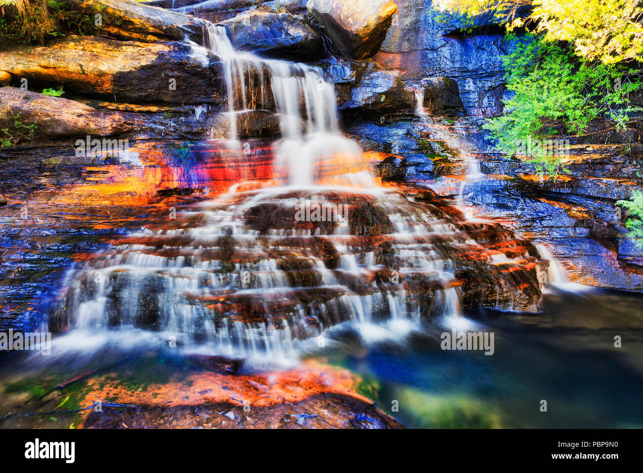 Wide split stream on top section of Wentworth falls cascade flowing over sandstone rocks down to Wide split stream on top section of Wentworth falls cascade flowing over sandstone rocks down to