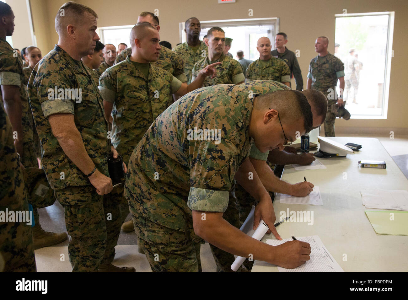 U.S. Marines stationed at Marine Corps Base Camp Pendleton, sign check-in rosters for the Manpower Management Enlisted Assignment Executive Overview Brief at MCB Camp Pendleton, California, July 19, 2018. The Marines that attended the brief were given a chance to meet the enlisted assignment executives and discuss the opportunities and changes that will take effect in Fiscal Year 2019. (U.S. Marine Corps photo by Lance Cpl. Drake Nickels) Stock Photo