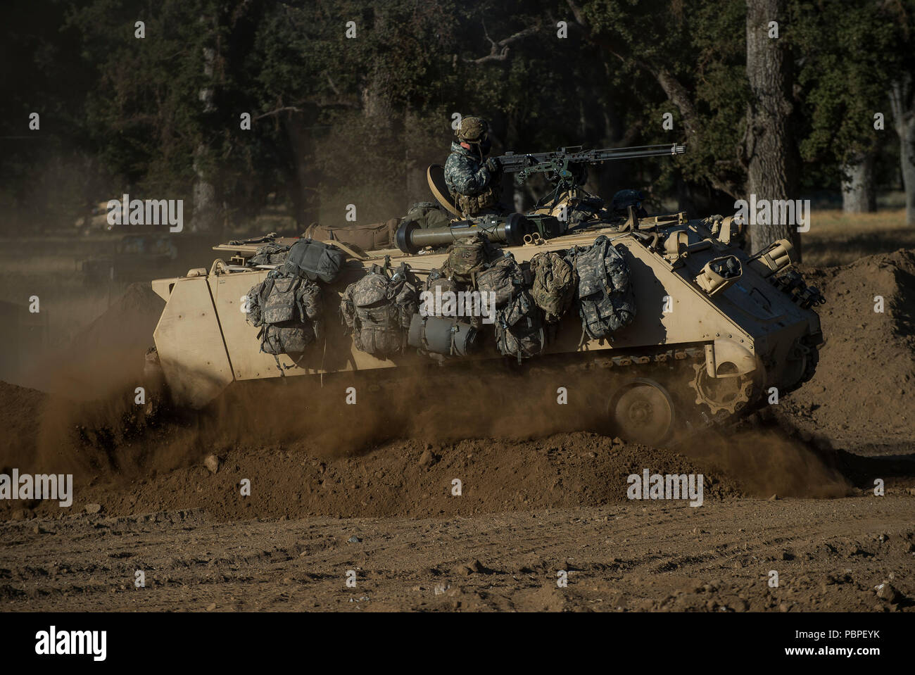 U.S. Army Reserve combat engineer Soldiers from the 374th Engineer Company, of Concord, California, ride through a berm in an M113 Armored Personnel Carrier on a combined arms breach during a Combat Support Training Exercise (CSTX) at Fort Hunter Liggett, California, July 22, 2018. This rotation of CSTX runs through the month of July, training thousands of U.S. Army Reserve Soldiers from a variety of functions to include military police, medical, chemical, logistics, transportation and more. (U.S. Army Reserve photo by Master Sgt. Michel Sauret) Stock Photo