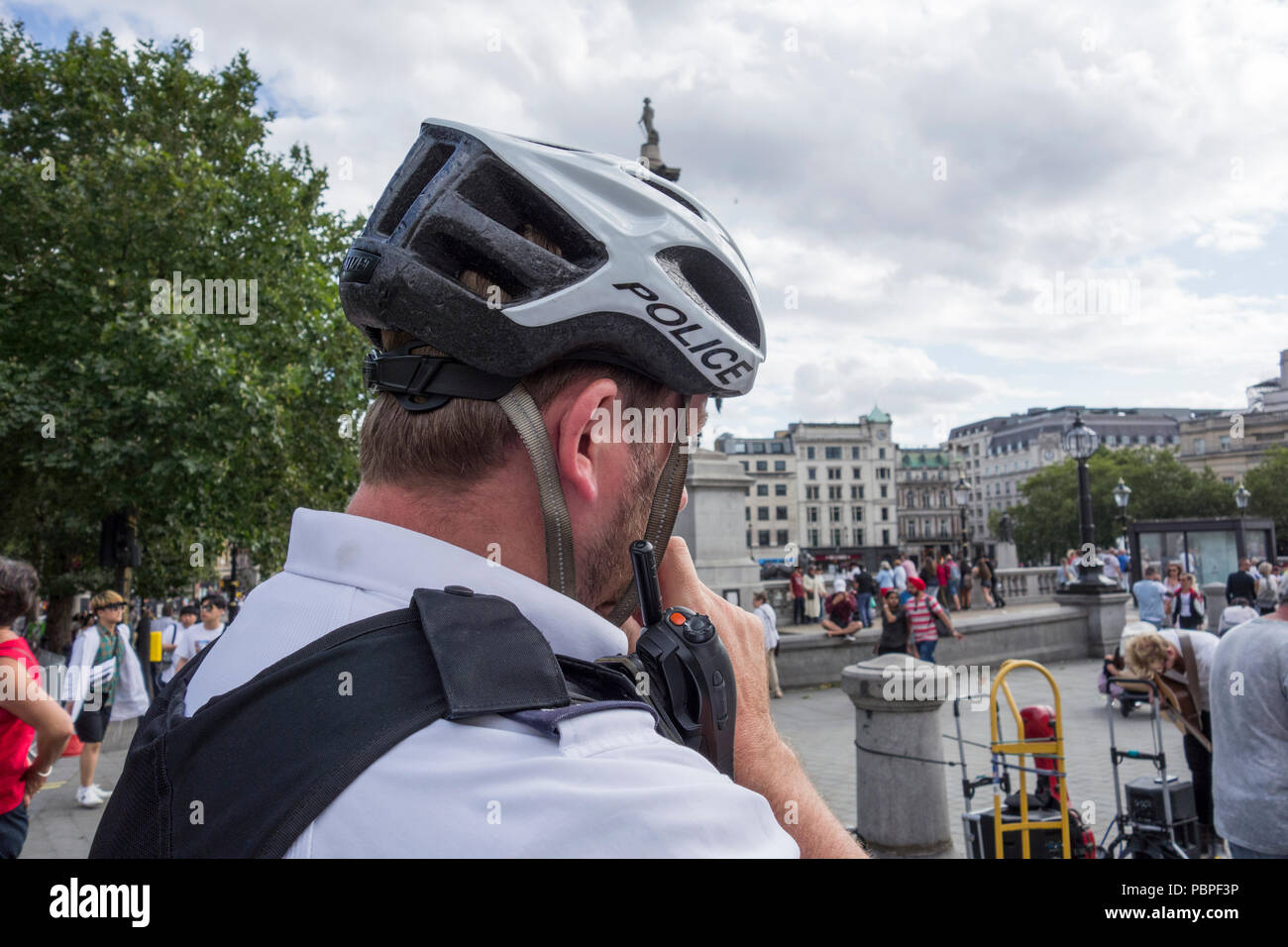 Police cyclist wearing protective headgear in Trafalgar Square, London