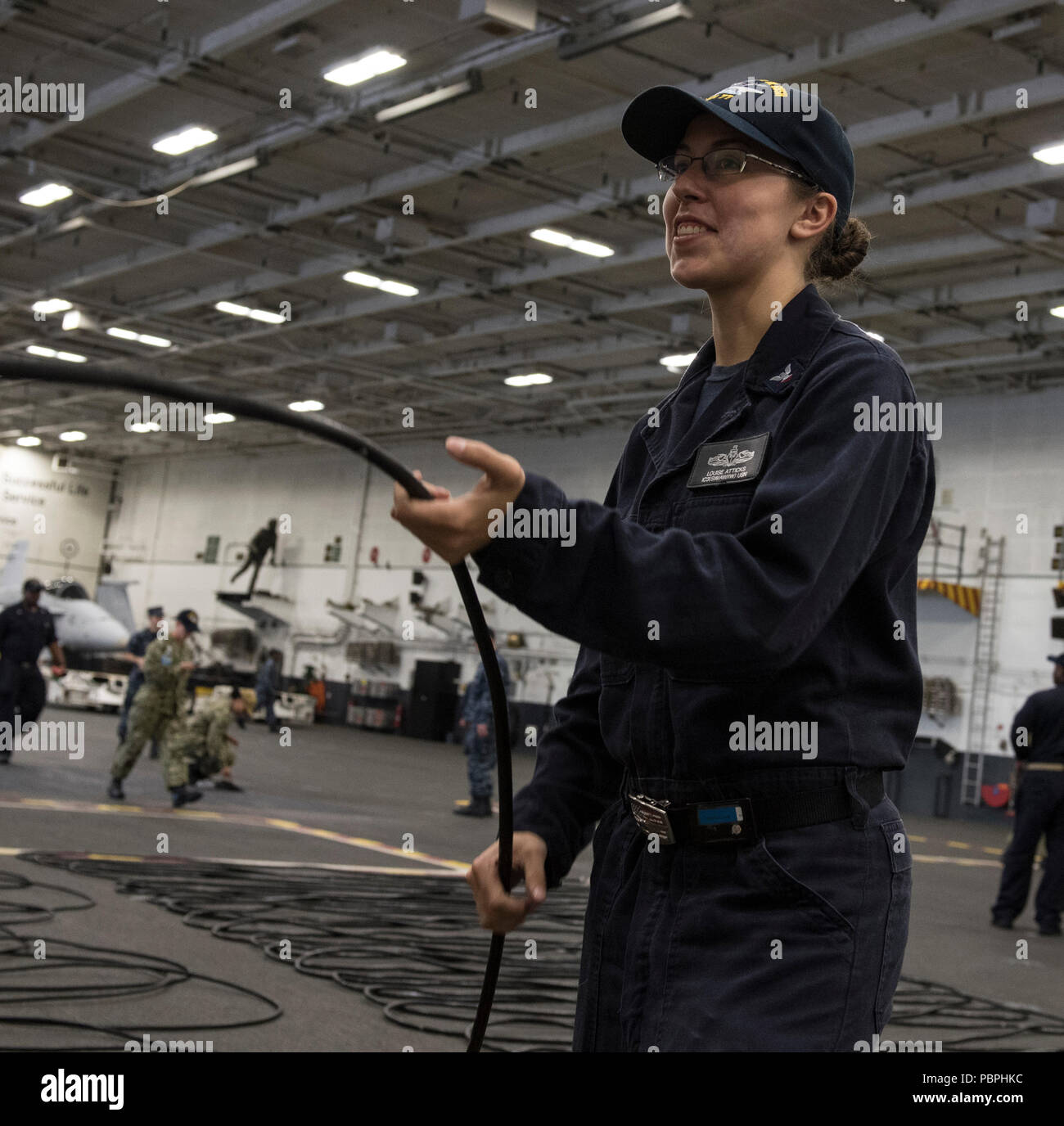 180725-N-FA806-0061 NORFOLK, Va. (July 25, 2018) Interior Communications Electrician 3rd Class Louise Atticks, from Harrisburg, Pennsylvania, coils plain old telephone system (POTS) lines during cleaning stations aboard the aircraft carrier USS George H.W. Bush (CVN 77). The ship is in port in Norfolk, Virginia, conducting routine training exercises to maintain carrier readiness.  (U.S. Navy photo by Mass Communication Specialist 3rd Class Roland John) Stock Photo