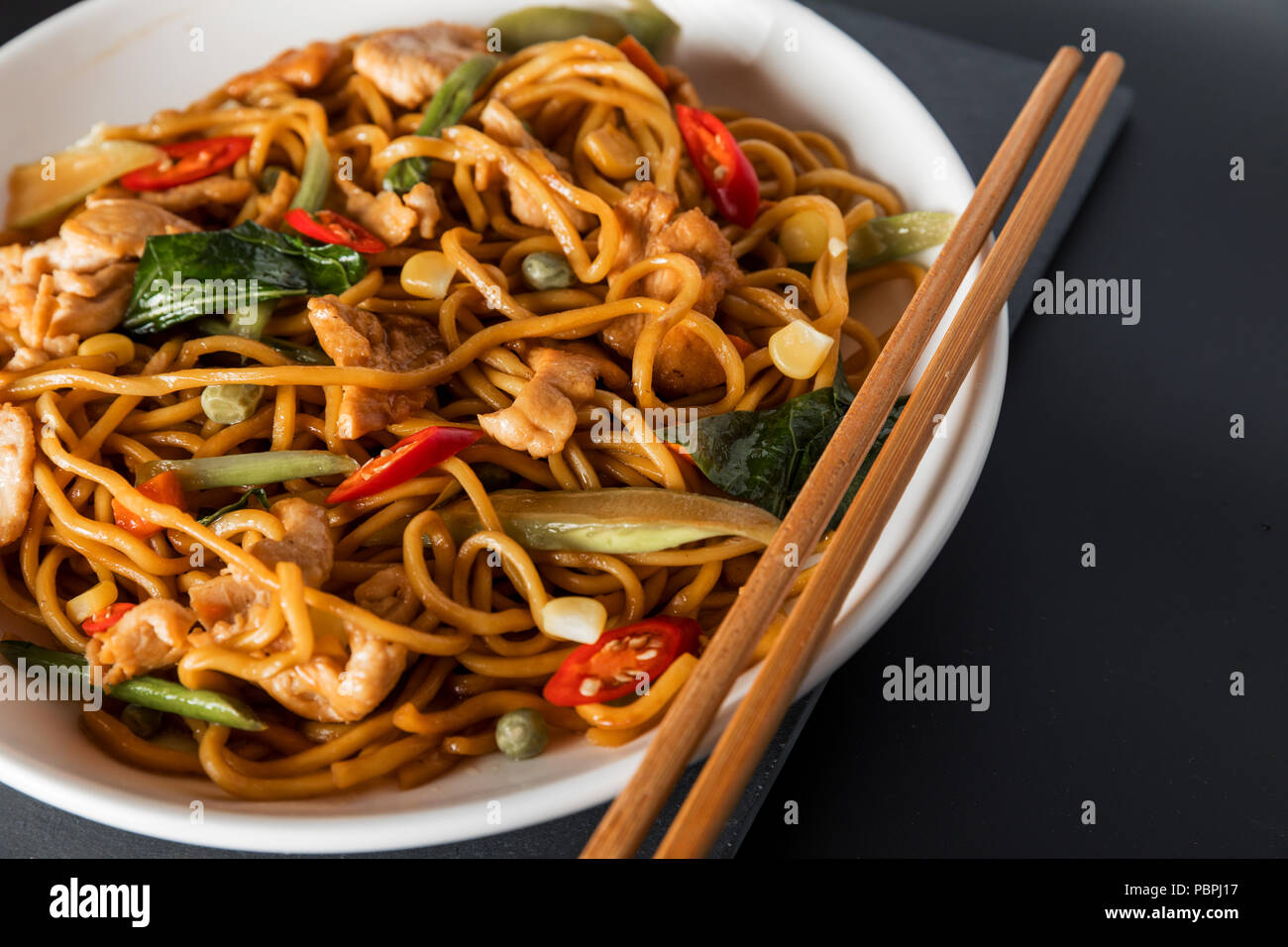 wok stir-fry egg noodles with fried chicken and thai spices and,  traditional spicy asian cuisine food Stock Photo - Alamy