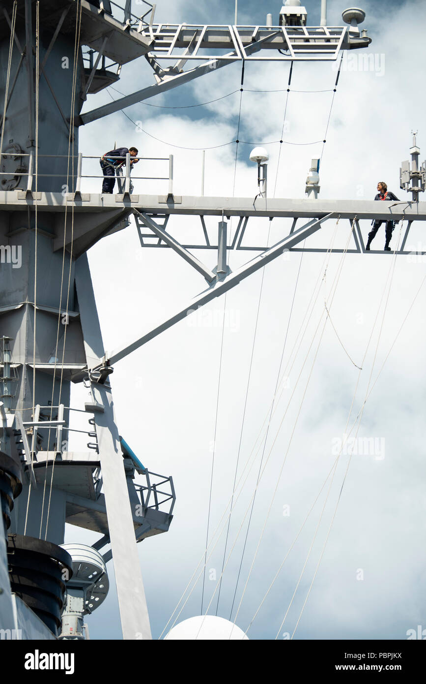 180725-N-ZA692-0050 Pacific Ocean (July 25, 2018) Quartermaster 1st Class Mikayla Lovett, left, and Quartermaster 2nd Class Ashley Martindale prepare to lower a signal flag aboard guided-missile destroyer USS Preble (DDG 88). Preble is currently underway conducting routine operations in the 3rd Fleet area of responsibility. (U.S. Navy photo by Mass Communication Specialist 2nd Class Anita C. Newman/Released) Stock Photo