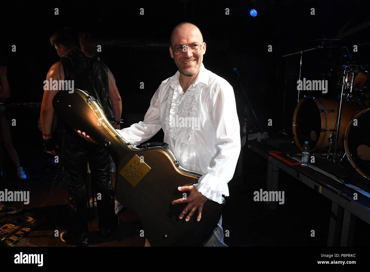 Bavaria, Germany. 28th July, 2018. The winner, Patrick 'Ehrwolf' Culek, standing on stage after the award ceremony in the backstage of the 15th German Air Guitar Championship and celebrating his trophy, an air guitar case. Credit: Felix Hörhager/dpa/Alamy Live News Stock Photo