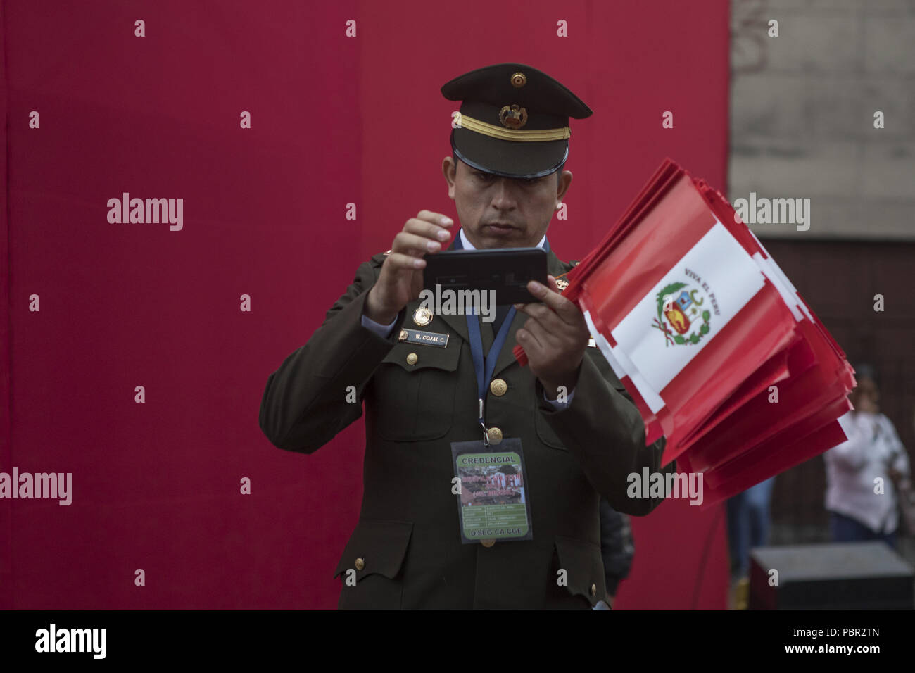 Lima, Lima, Peru. 29th July, 2018. A police officer seen taking pictures with his mobile phone.Members of Peru's armed forces, coastguard, search & rescue, and police march in full uniform during the country's Gran Parada Militar. This parade always occurs the day after Peru's Independence Day marking the official end of festivities across the nation. Credit: Guillermo Gutierrez/SOPA Images/ZUMA Wire/Alamy Live News Stock Photo