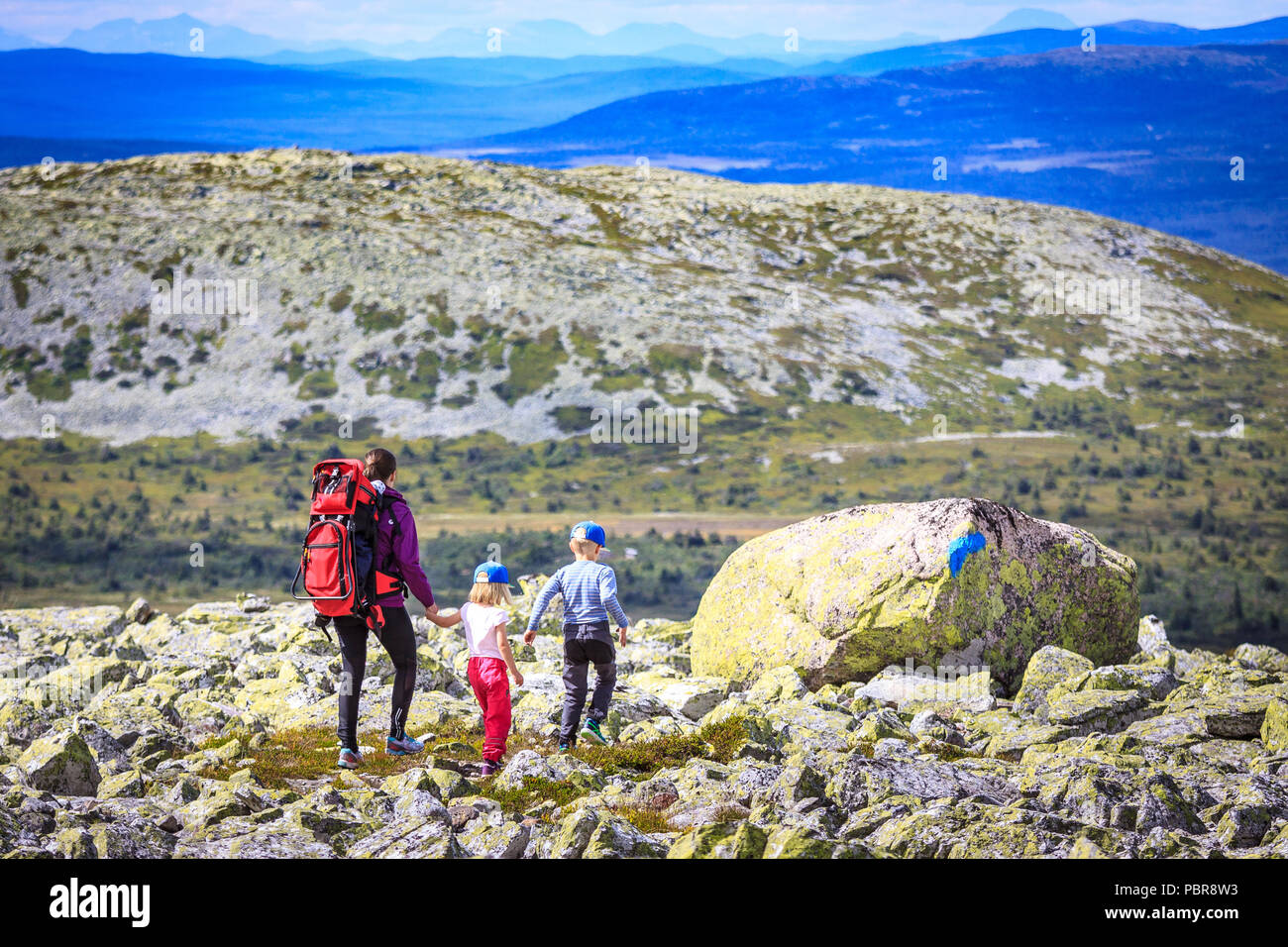 Family on hiking trip on the mountain. Large boulders create a difficult passage. Stock Photo