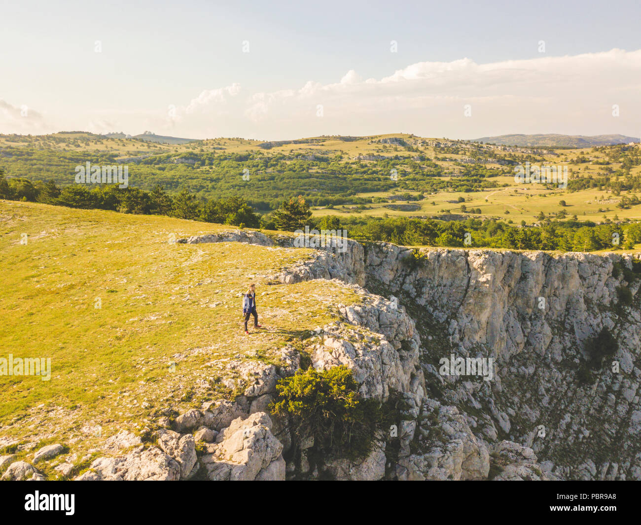 aerial wide angle panorama view of man walking on the mountain edge