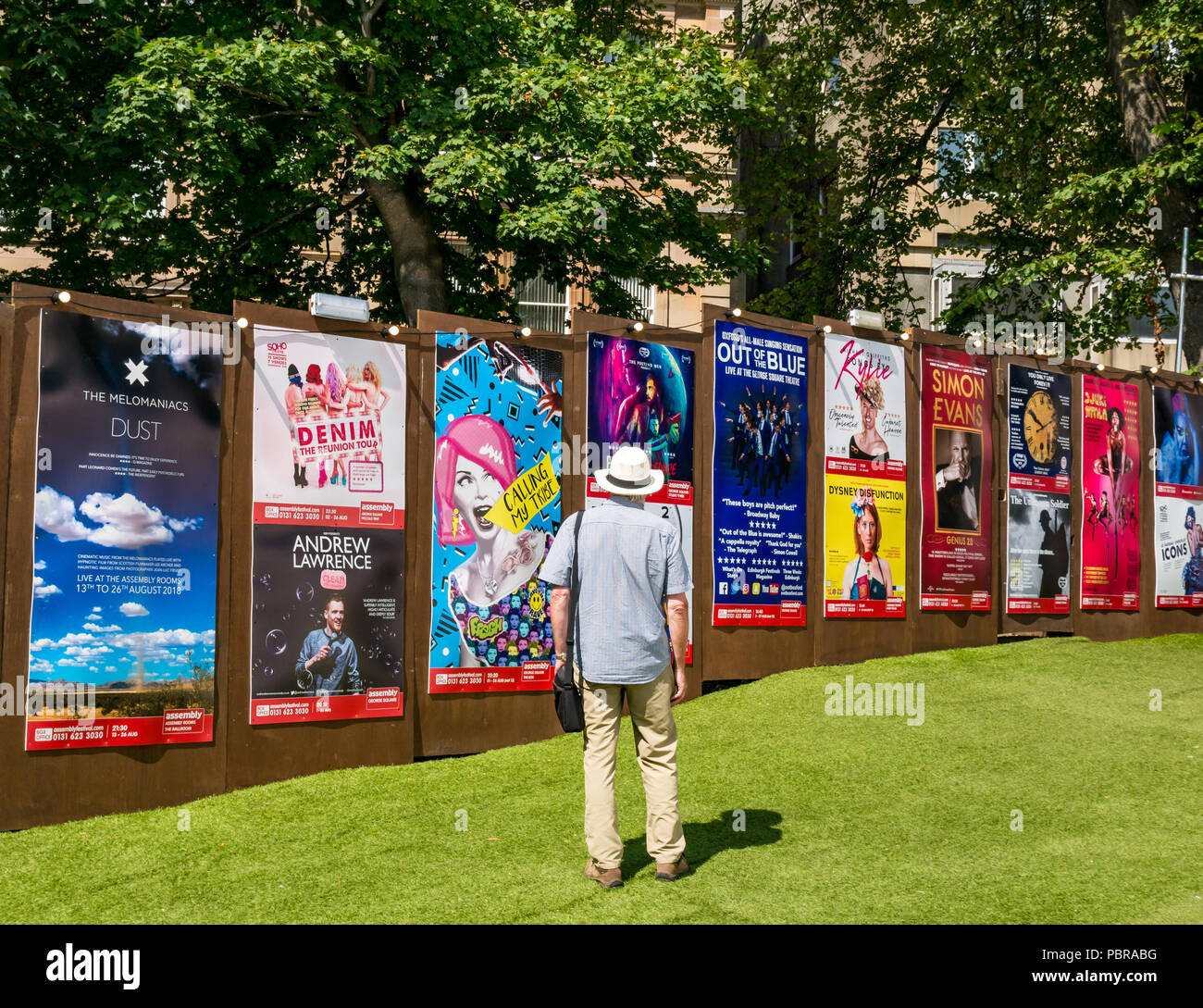 Man wearing Panama hat looks at Edinburgh Fringe Festival posters, George Square Gardens, Edinburgh, Scotland, UK Stock Photo