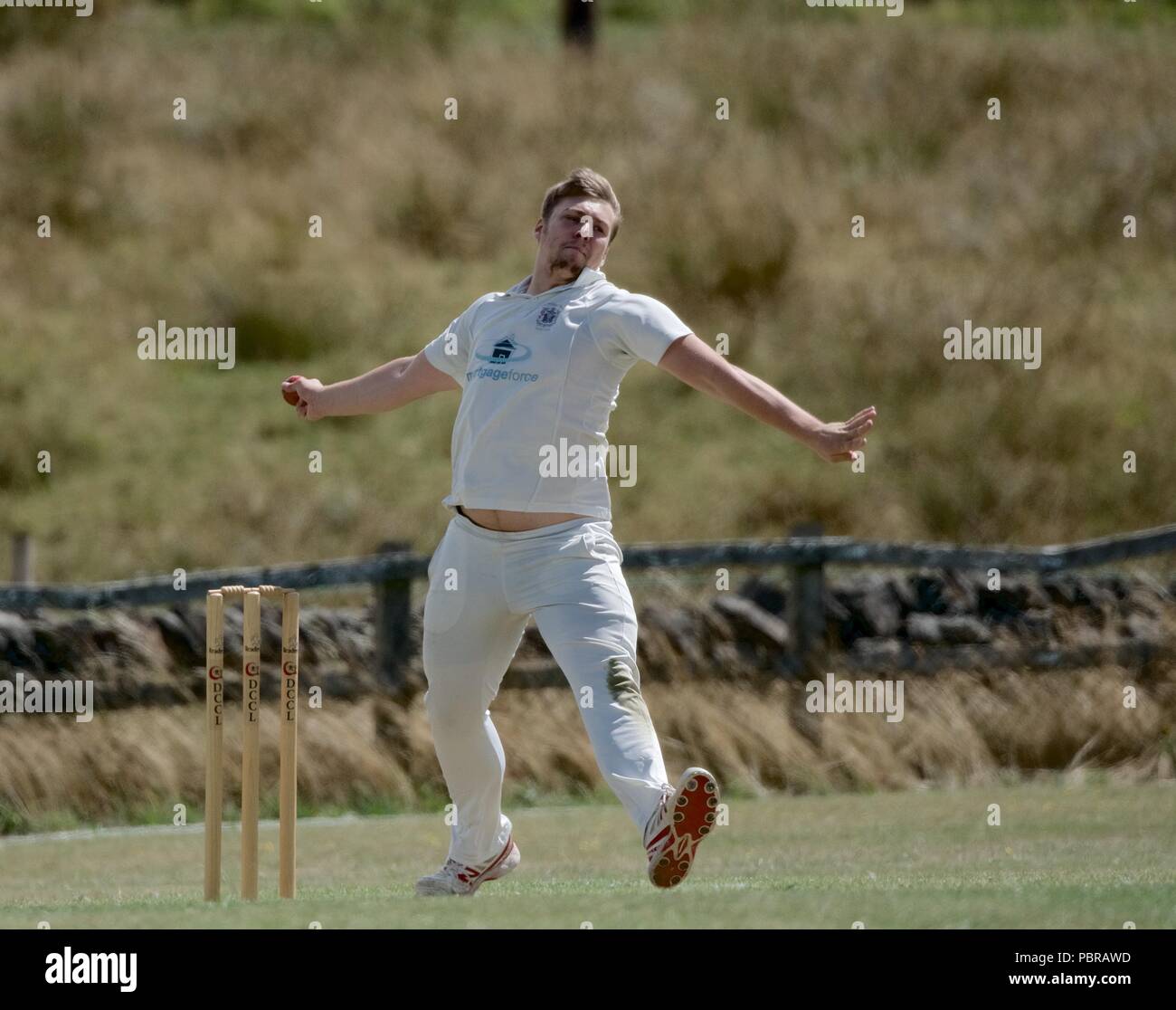 A fast bowler in action in a cricket match between Birch Vale and Thornsett second team and Stalybridge St Paul's second team. Stock Photo