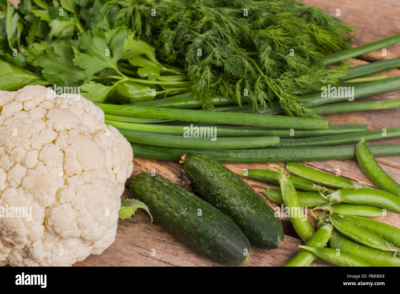 Fresh raw green vegetables for cooking salad. Top view. Wooden table ...