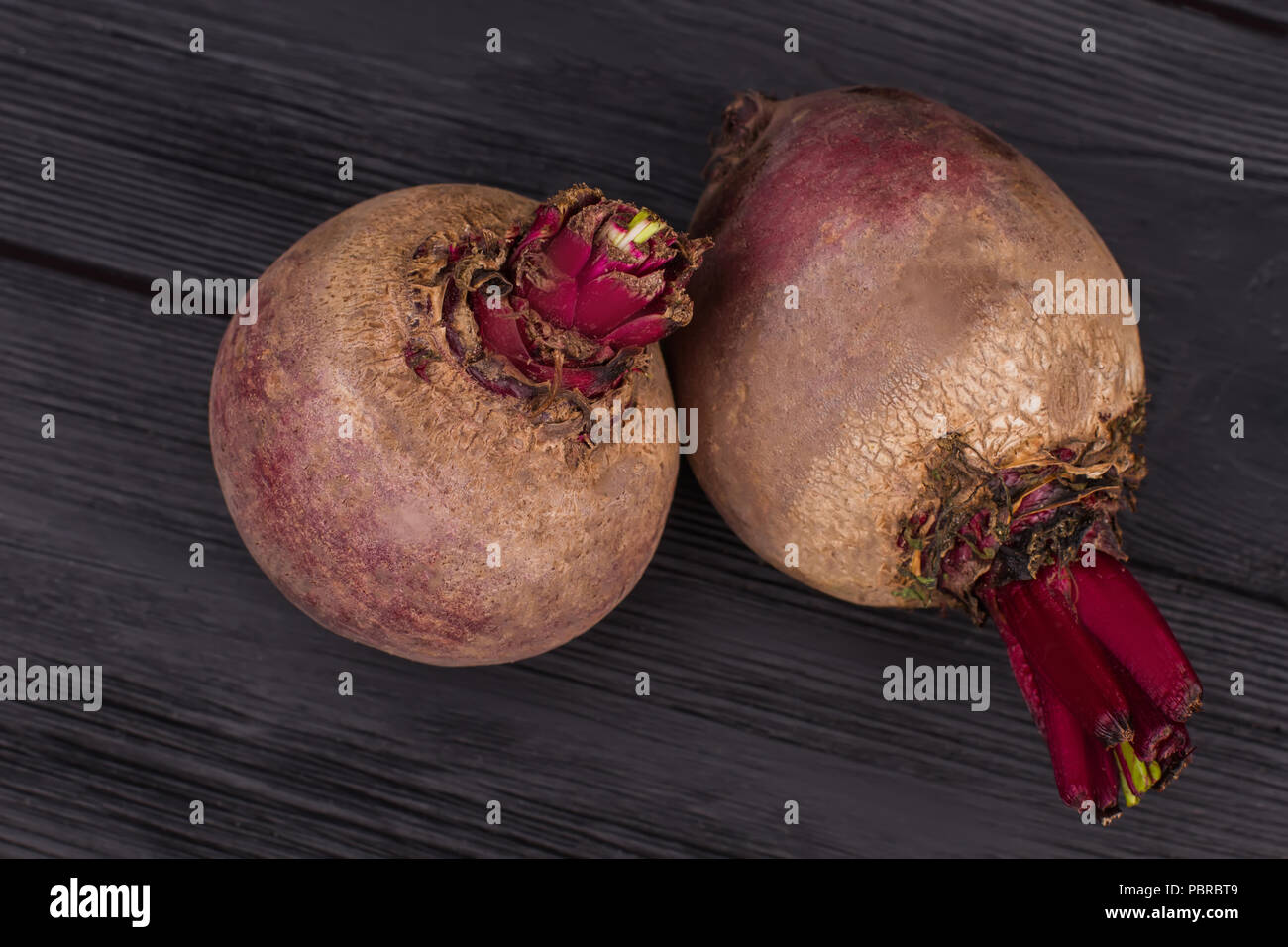Purple raw organic beetroots. Close up, top view. Black wooden surface ...