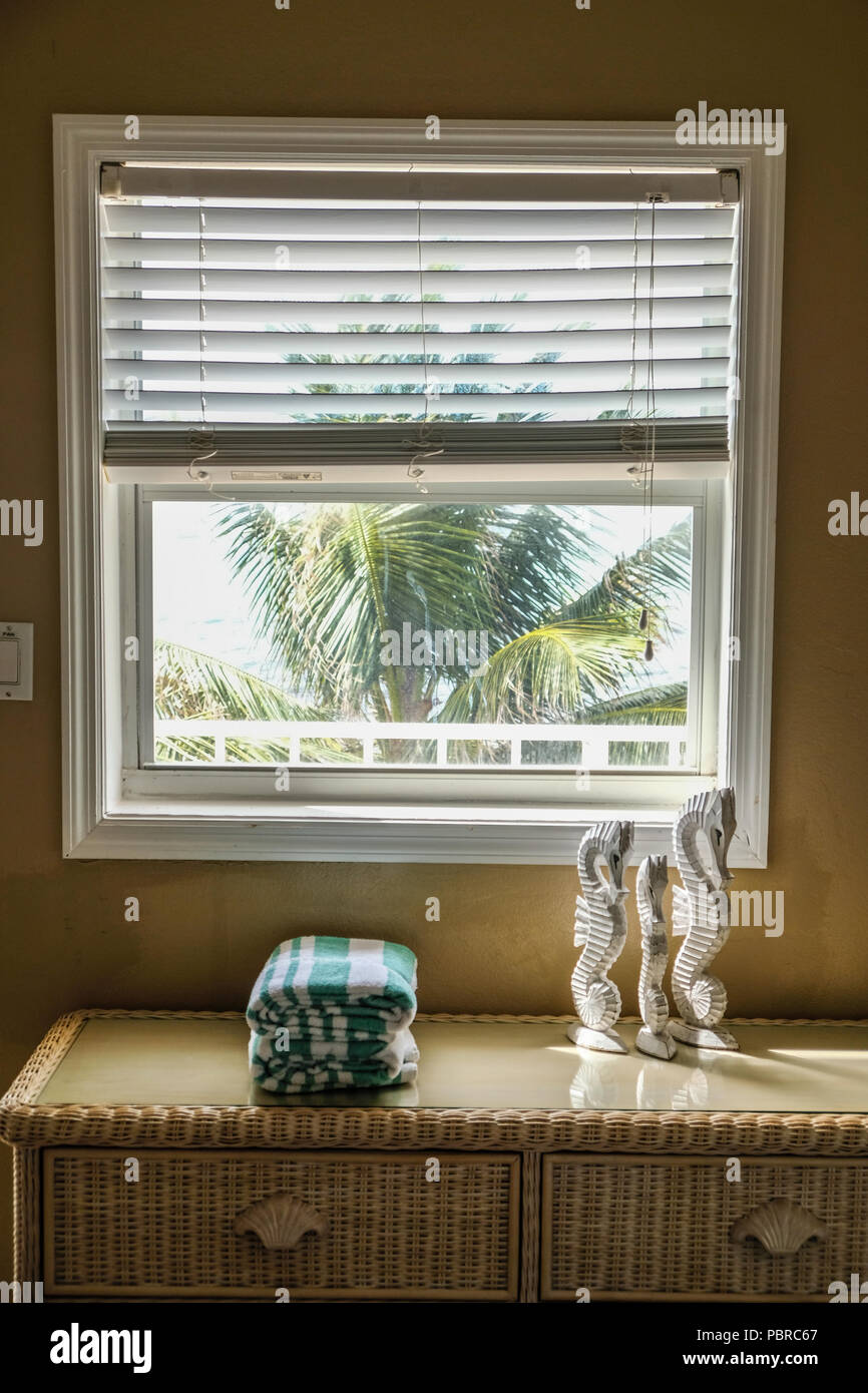 Folded beach towns on dresser in front of window at Cayman Island Stock Photo