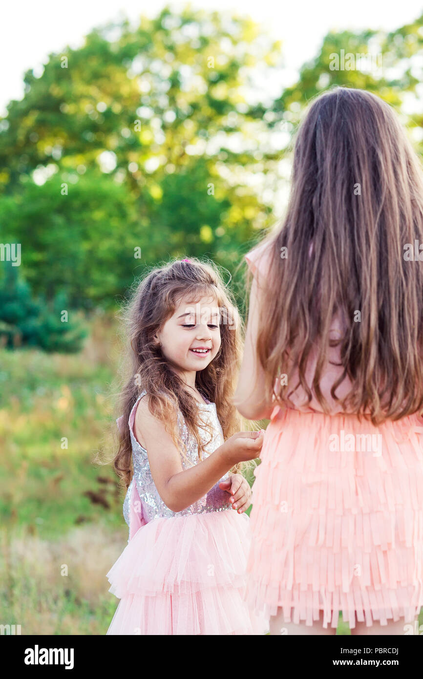 Portrait of Two Happy little girls having fun and embracing  at sunny summer day Stock Photo