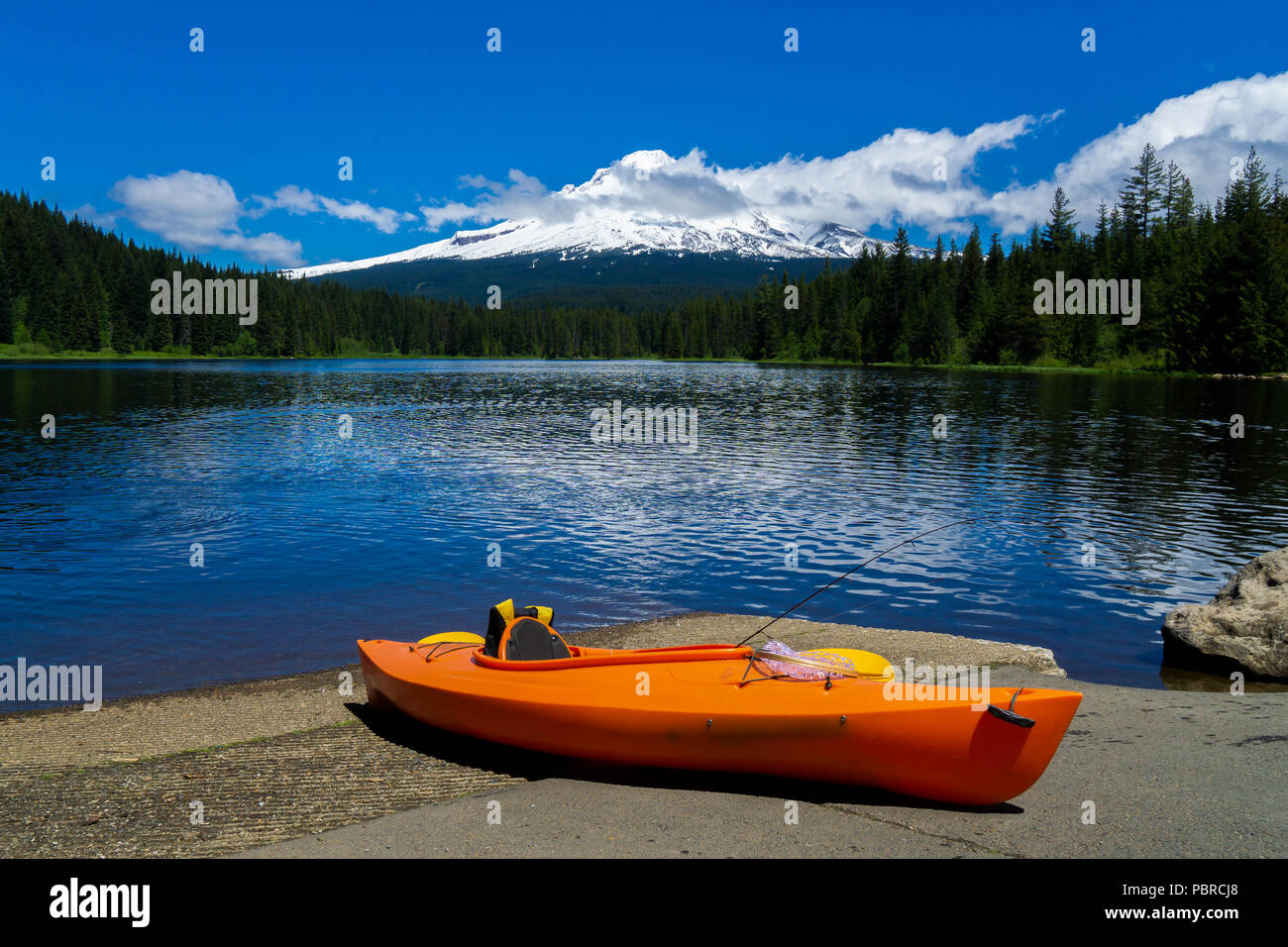 Kayak lying on the ground at Trillium Lake with the Mt. Hood in the background on a sunny day of early summer. Recreation concept with copy space, usa Stock Photo