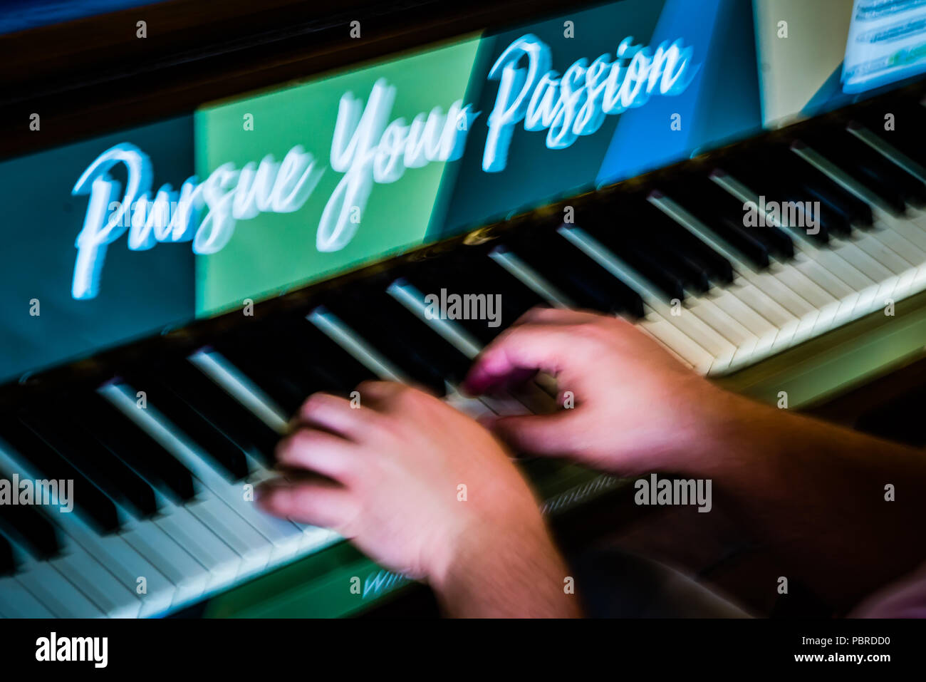 Pursue your passion piano player plays piano music on art project  installation of pianos in public areas Stock Photo - Alamy