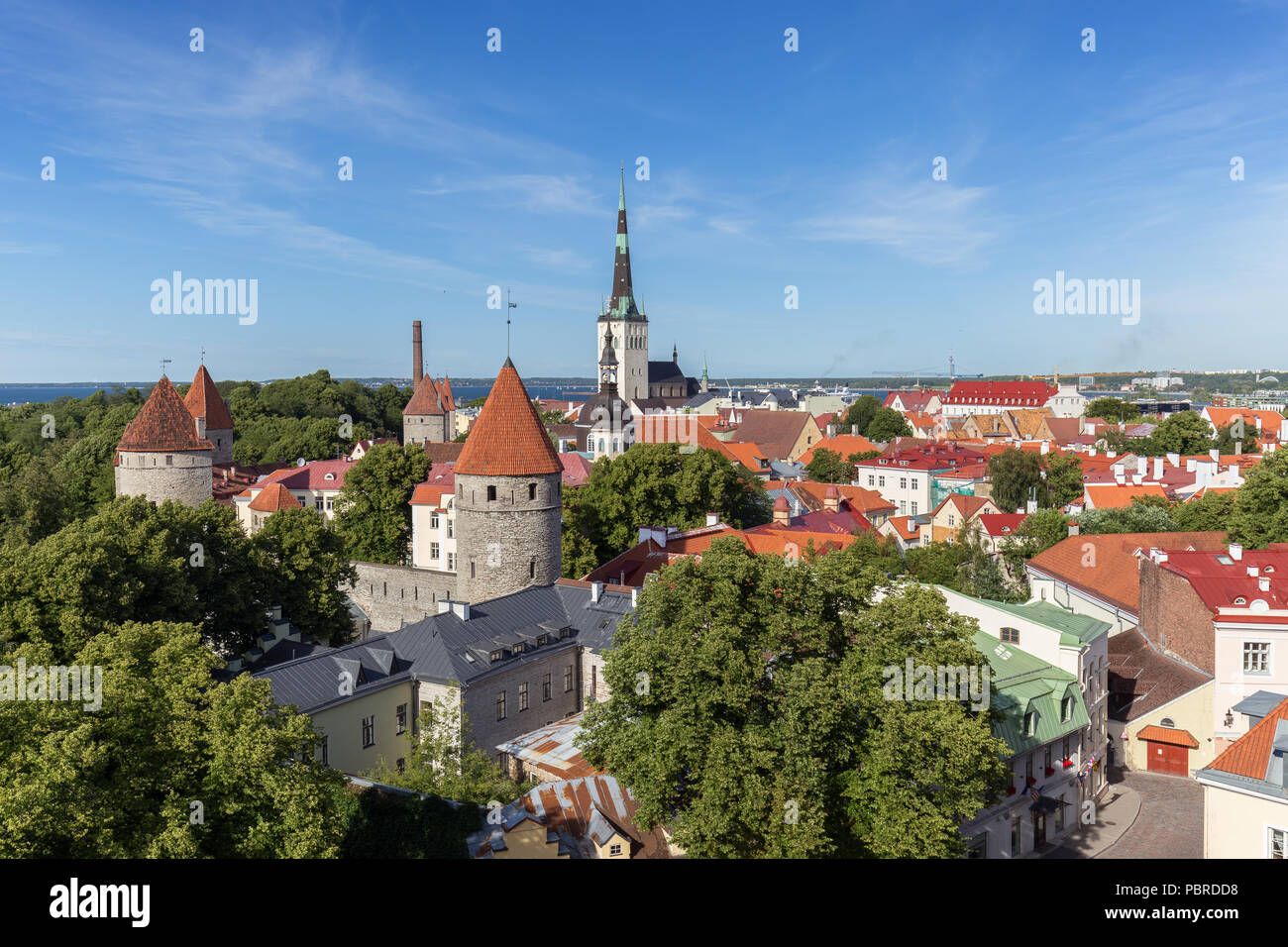 City walls' and St. Olaf's (or Olav's) church's towers and other buildings at the Old Town in Tallinn, Estonia, viewed from above in the summer. Stock Photo