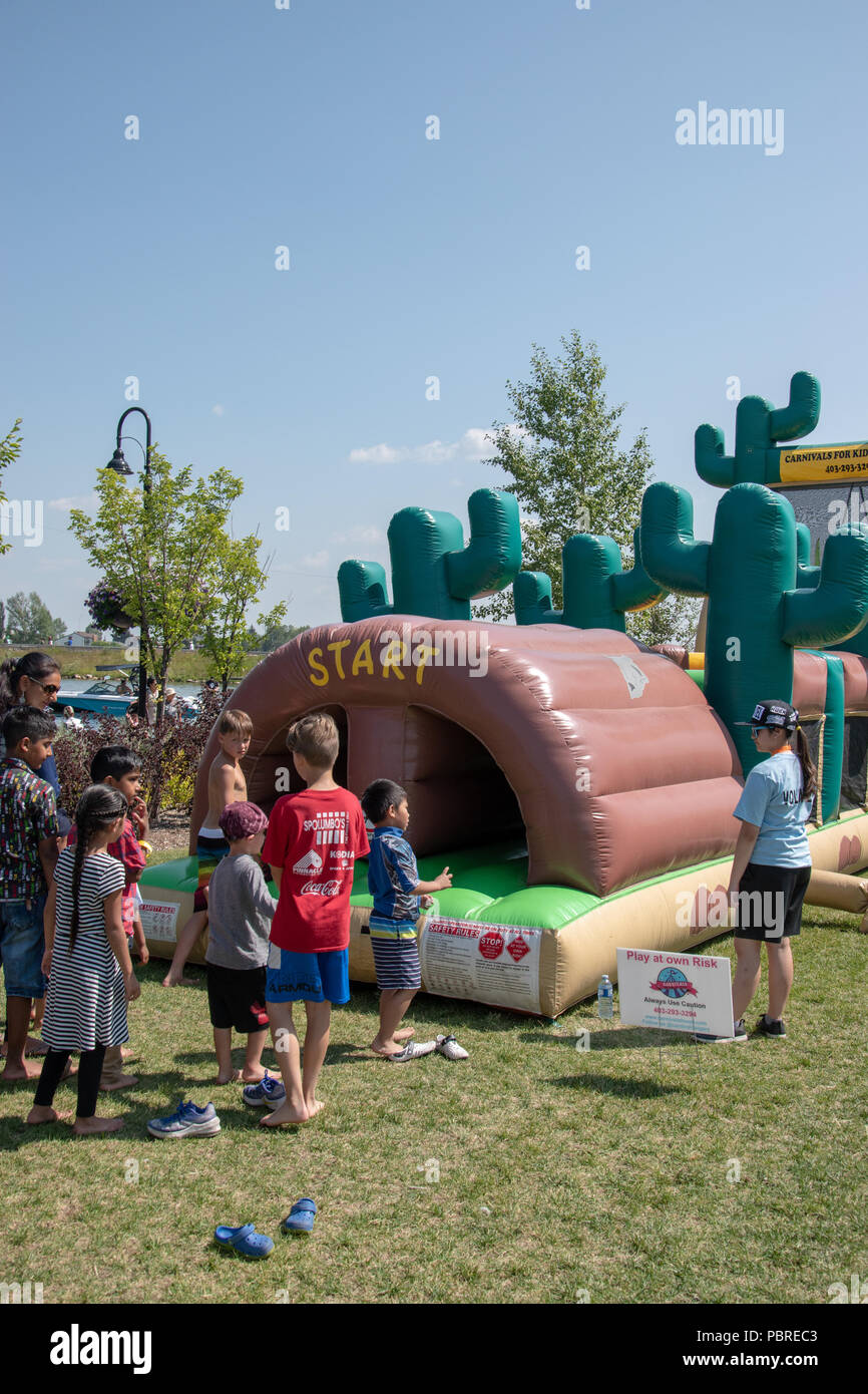 Children waiting to enter the inflatable obstacle at the Chestermere Water Festival, Chestermere, Alberta, Canada Stock Photo