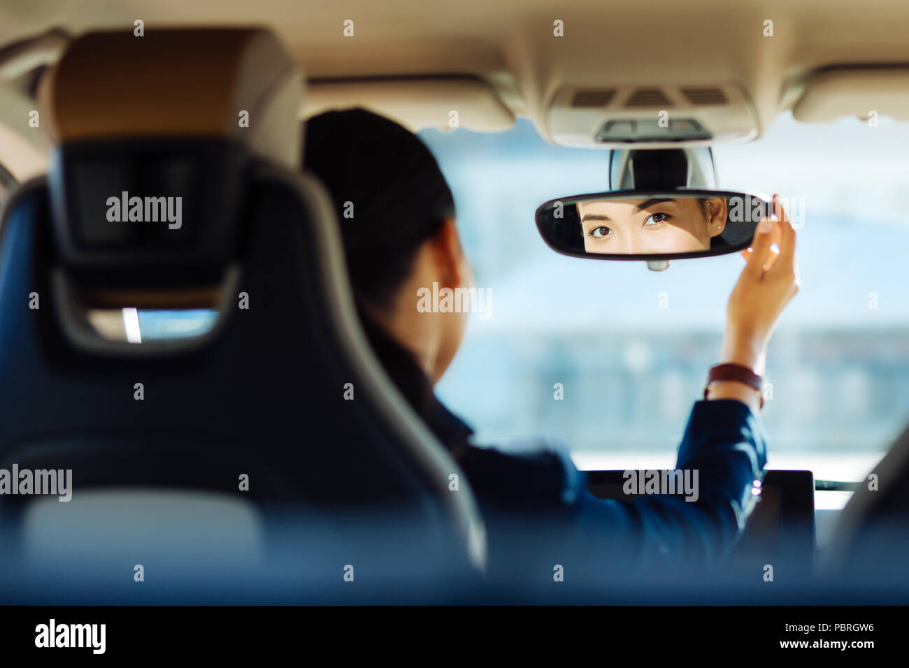 Positive smart woman fixing the rearview mirror Stock Photo Alamy