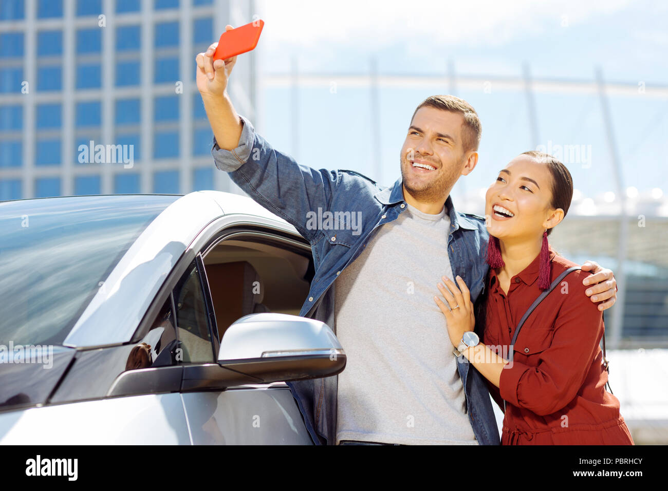 Delighted positive couple looking into the smartphone camera Stock Photo