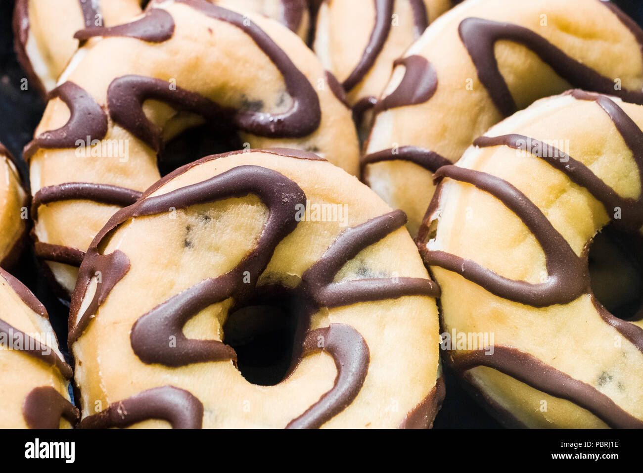 Many delicious sweet chocolate donuts in the bakery Stock Photo
