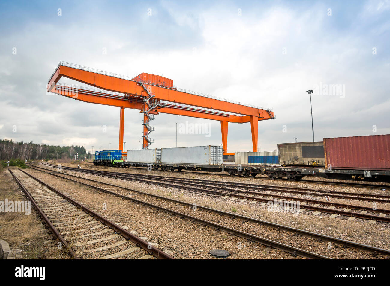 Cargo rail station with huge industrial overhead crane needed to railway transshipment Stock Photo