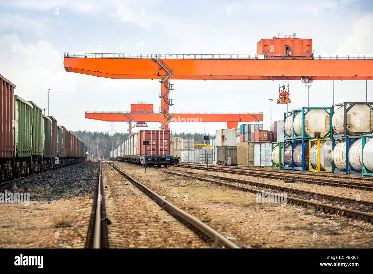 Cargo rail station with huge industrial overhead crane needed to railway transshipment Stock Photo