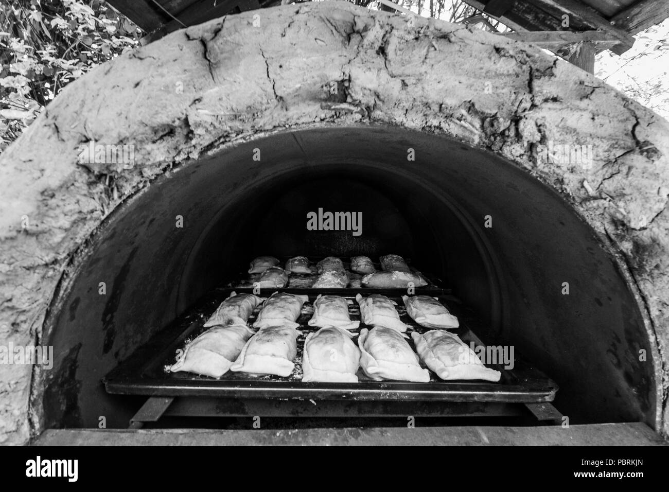 Traditional bread baking and traditional Pine pies at Chile inside a stone homemade oven Stock Photo