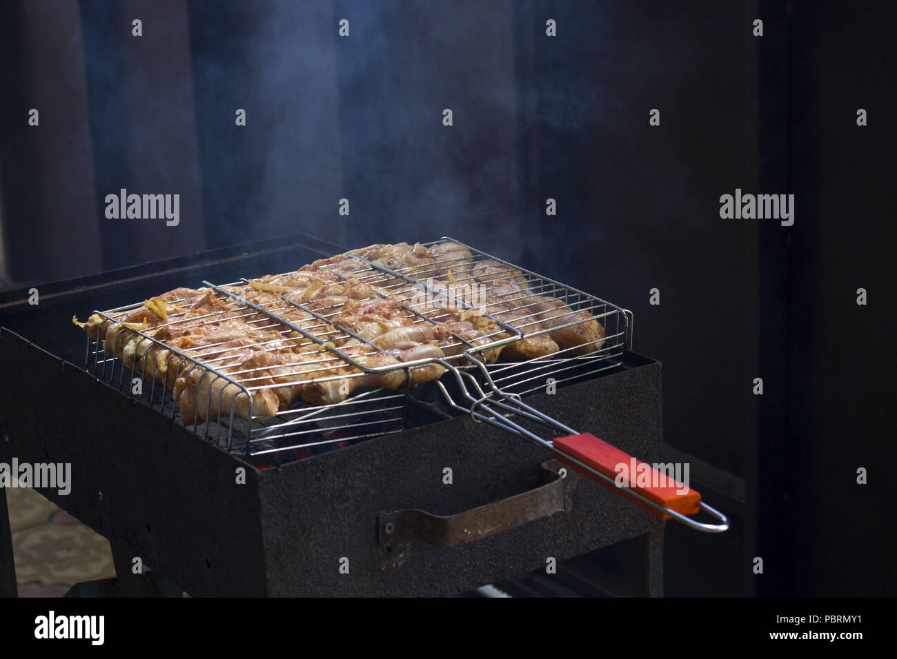 cooking chicken legs in the grill summer vacation outdoor food Stock Photo