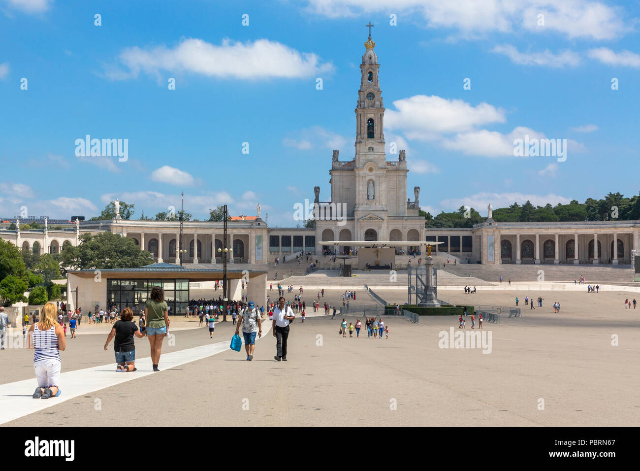 Rear view of worshippers crawling on their knees towards the Chapel of the Apparitions at the Sanctuary of Fatima Portugal Stock Photo