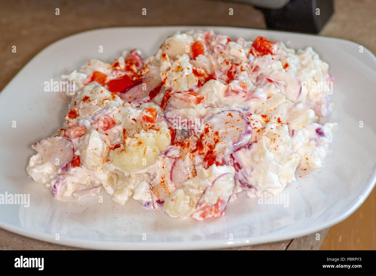 Cauliflower Smash a potato salad substitute that is low carb and good for those on the Keto Diet. Made of Cauliflower, radishes, sweet onions and red Stock Photo