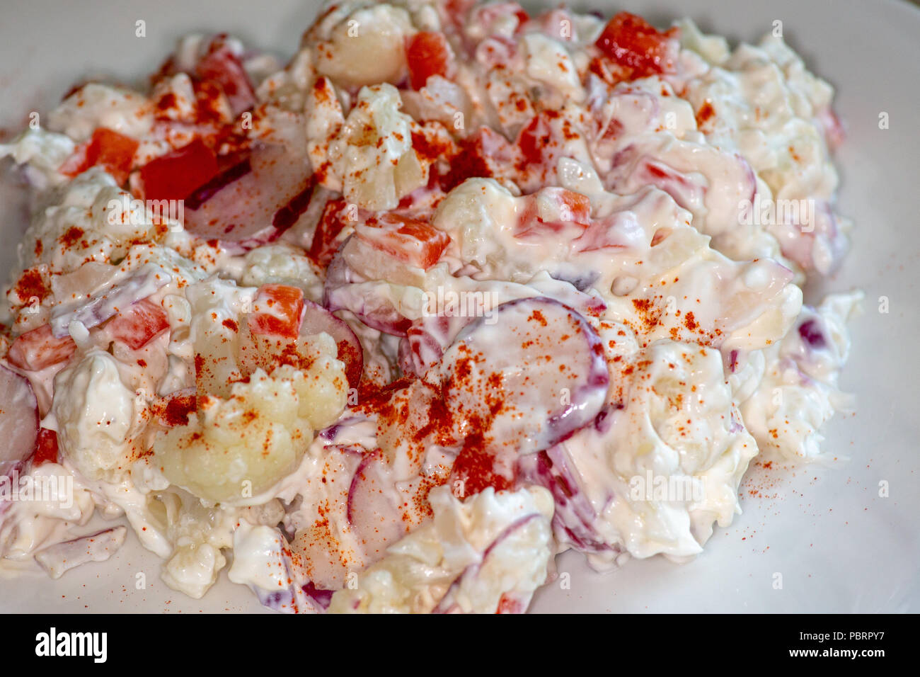 Cauliflower Smash a potato salad substitute that is low carb and good for those on the Keto Diet. Made of Cauliflower, radishes, sweet onions and red Stock Photo