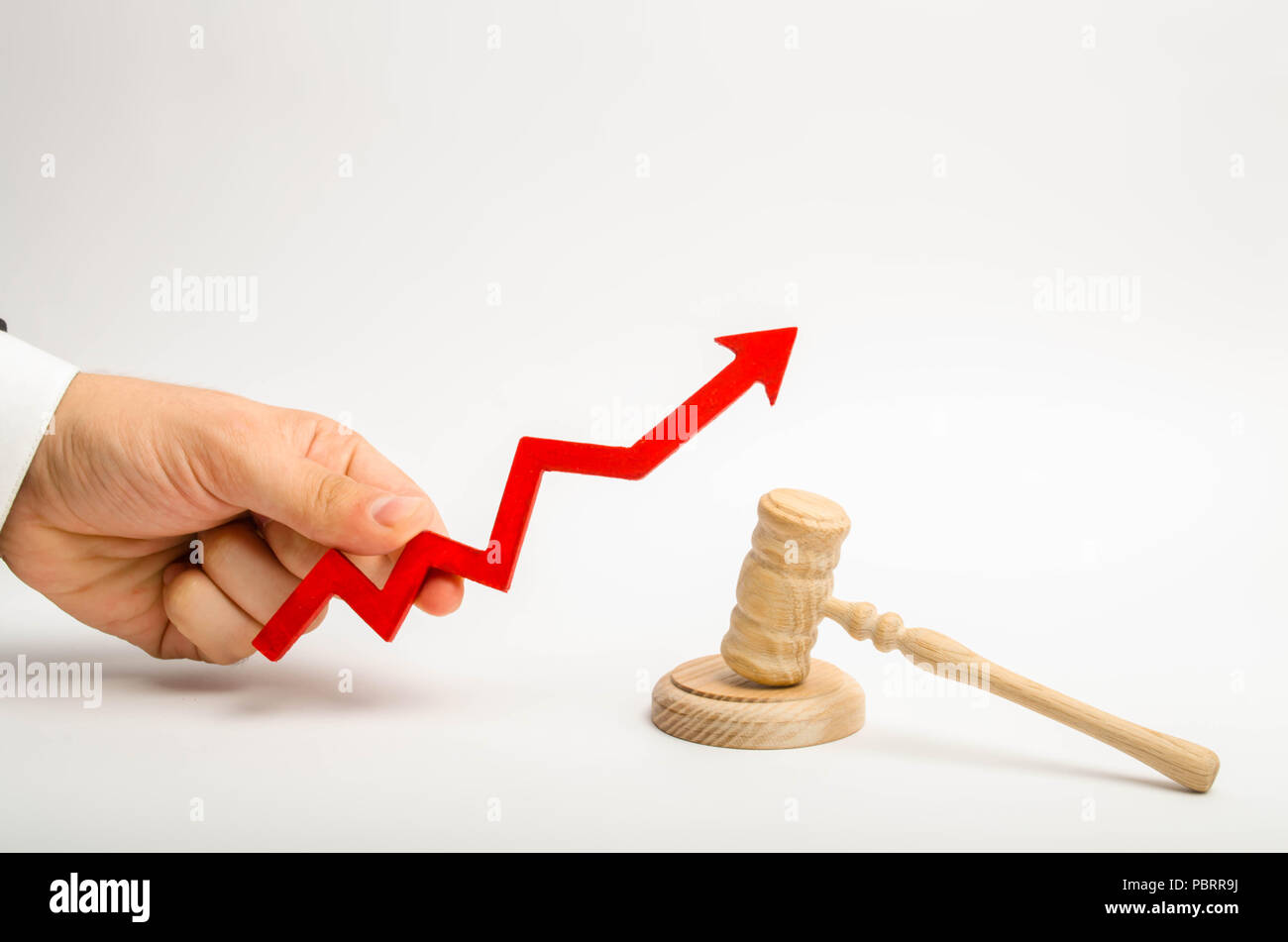 The hand holds the arrow up near the judge's hammer. The concept of increasing the percentage of disclosure of criminal cases, the last percent of acc Stock Photo
