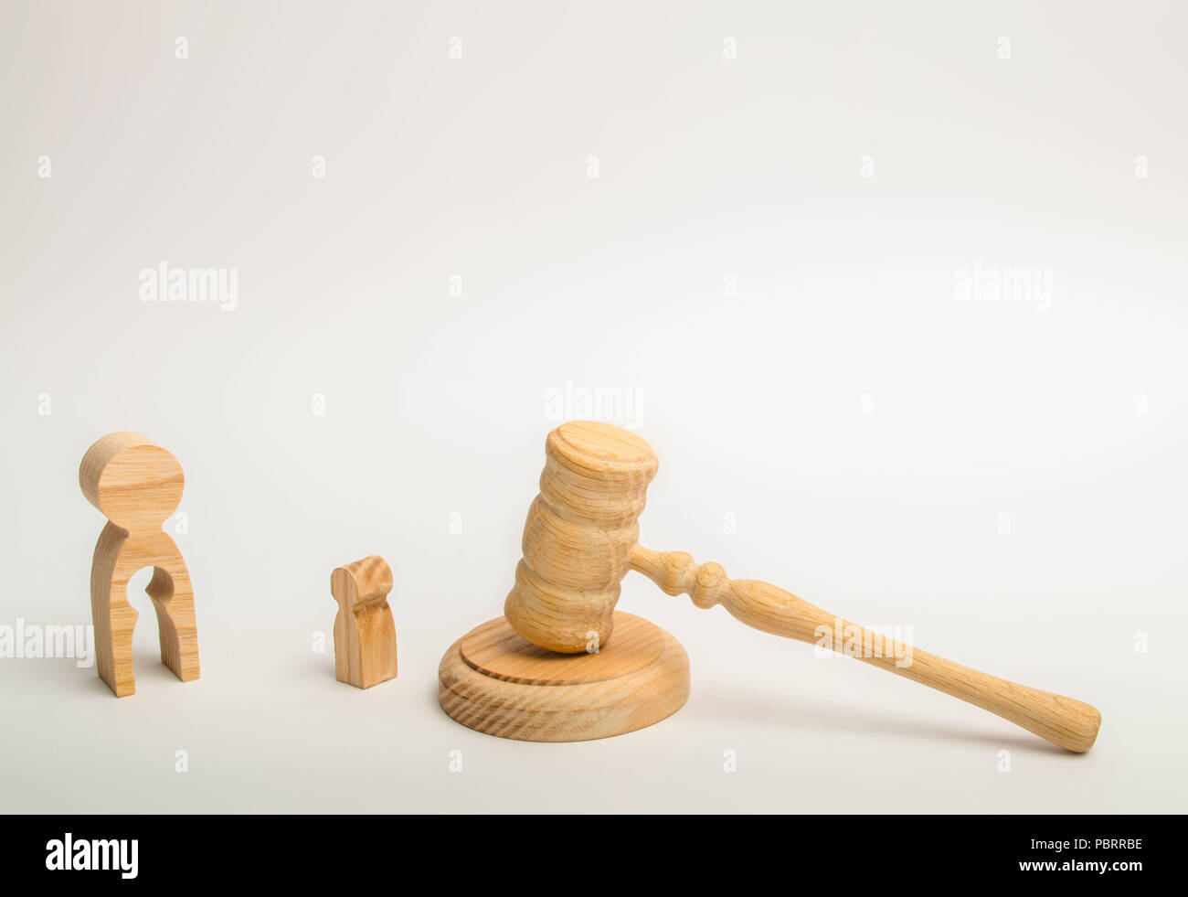 A figure of a man with a void in the form of a child inside the body stands near a child and the hammer of the judge. judicial process for the depriva Stock Photo