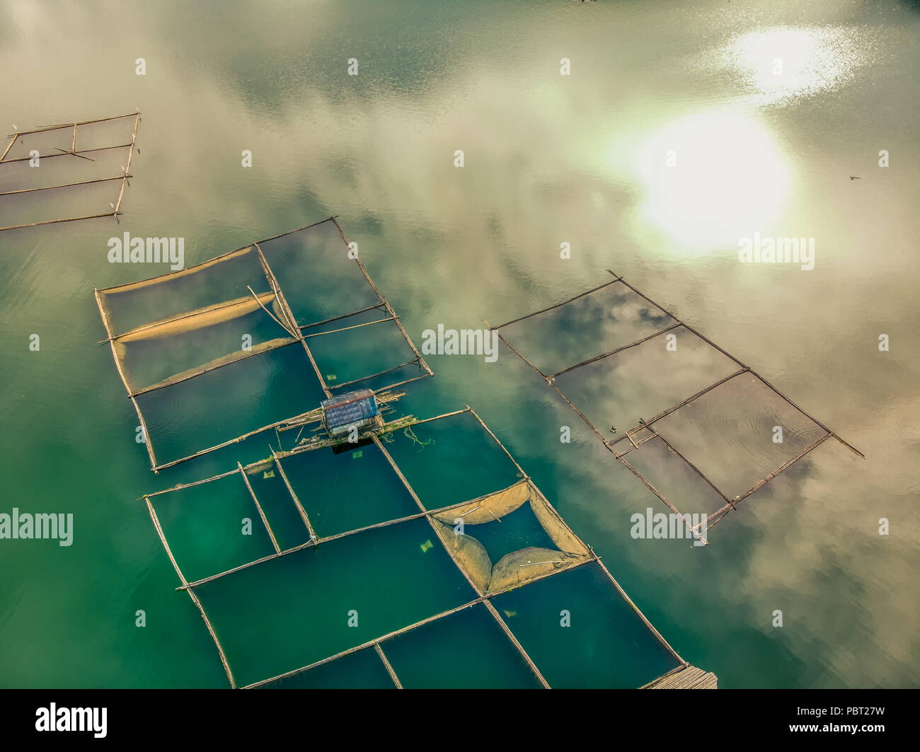 Bamboo rafts and cloud and sun reflection at Lake Mohicap, San Pablo City, Laguna, Philippines Stock Photo
