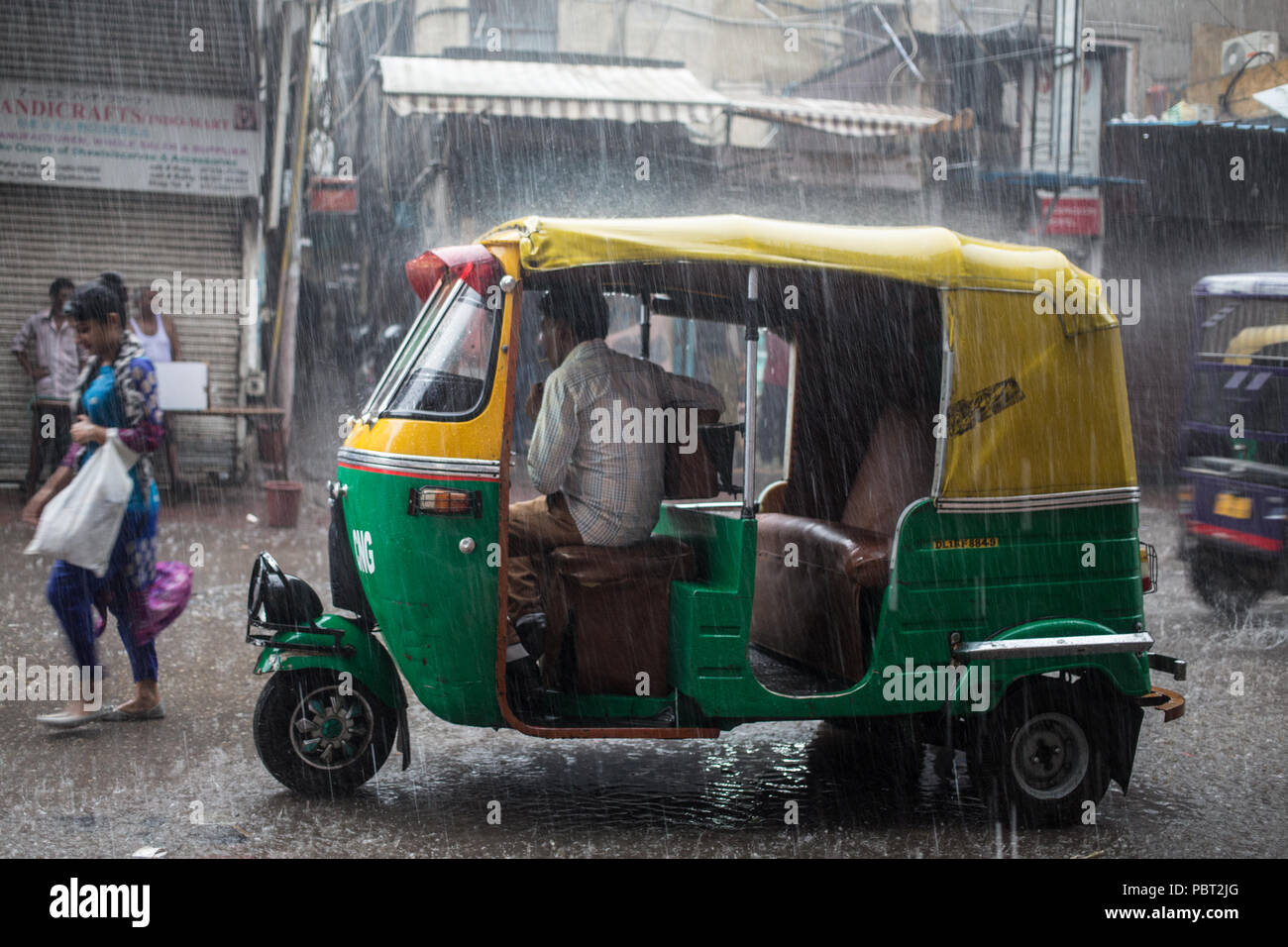 Auto rickshaw in heavy monsoon rains in New Delhi India. Stock Photo