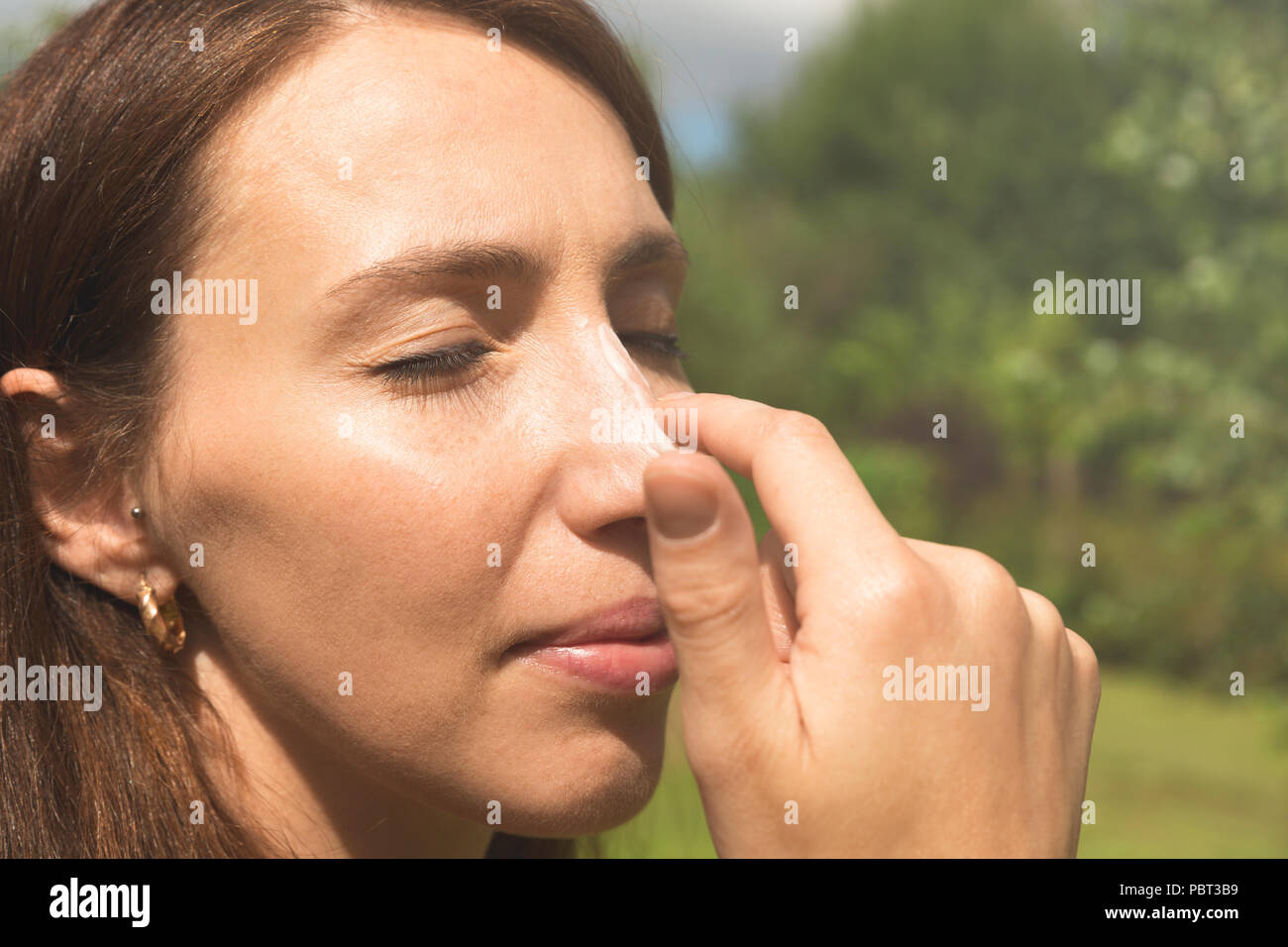 Woman applying sunscreen on her nose. Skincare. Body Sun protection sun