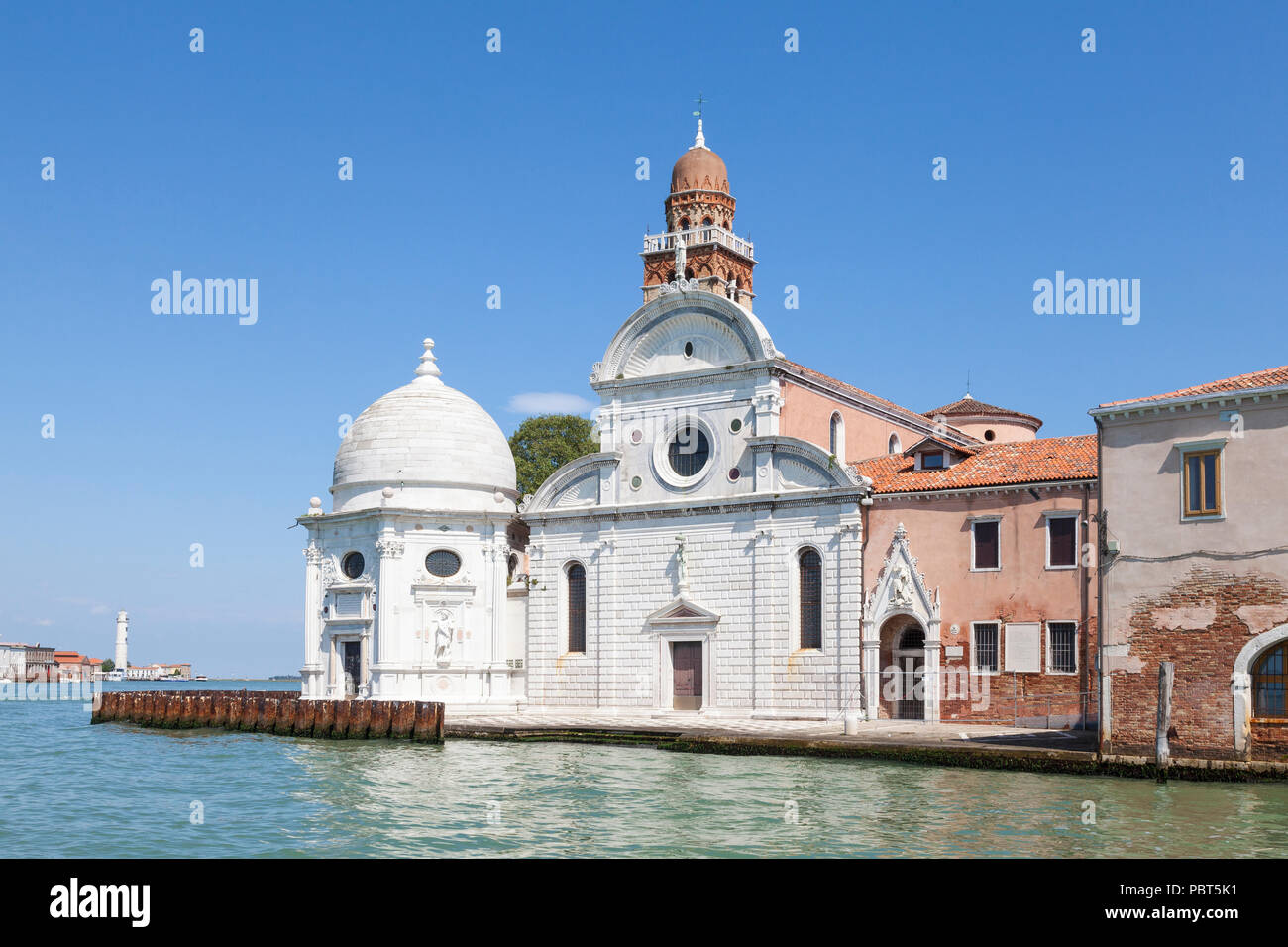 Renaissance facade  of Chiesa di San Michele in Isola, San Michele Island, Venice, Veneto, Italy. Built 1469. Cemetery island. Murano lighthouse behin Stock Photo