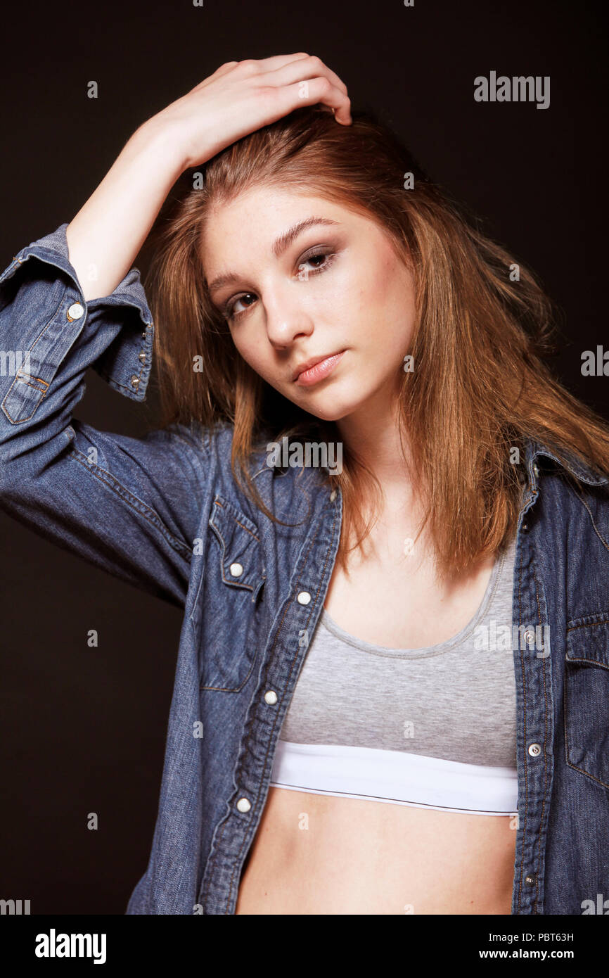 one young beautiful teenage girl, fashion model posing, studio black ...