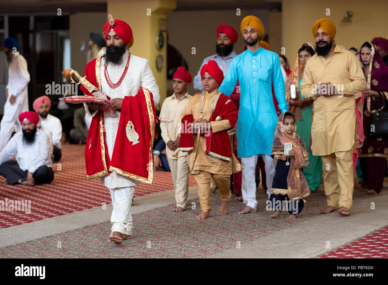 A Sikh groom, his little brother and others enter the temple for his wedding in Richmond Hill, Queens, New York. Stock Photo