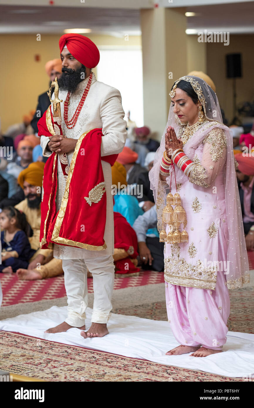 The bride and groom during their wedding ceremony at the Sikh Cultural Center in Richmond Hill, Queens, New York. Stock Photo