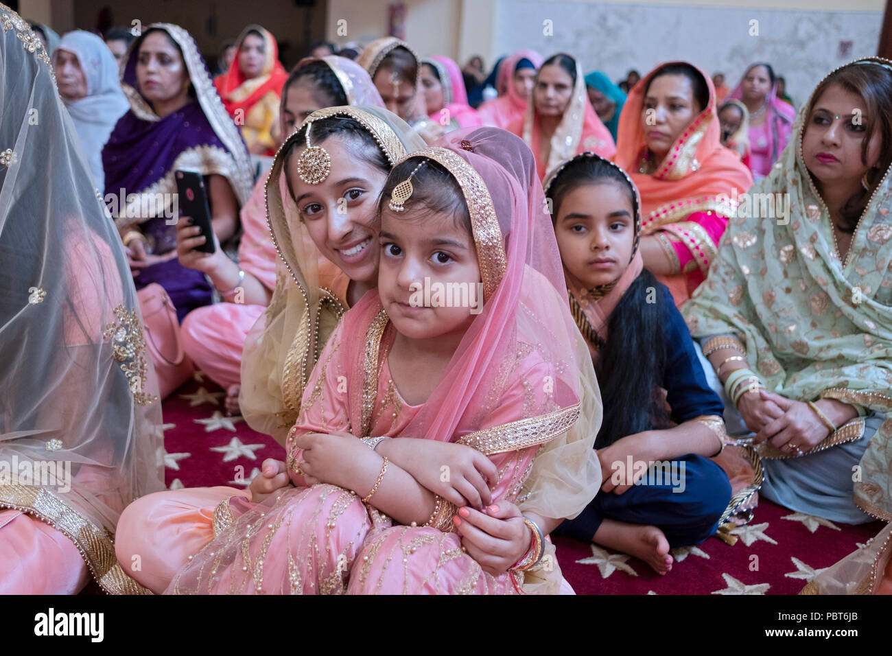 Female guests seated in the temple at a Sikh wedding in Richmond Hill, Queens, New York. Stock Photo