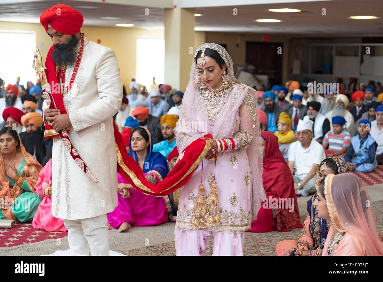 The bride and groom during their wedding ceremony at the Sikh Cultural Center in Richmond Hill, Queens, New York. Stock Photo