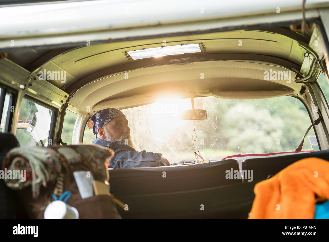 senior hipster in his van with a hiking bag in the back Stock Photo