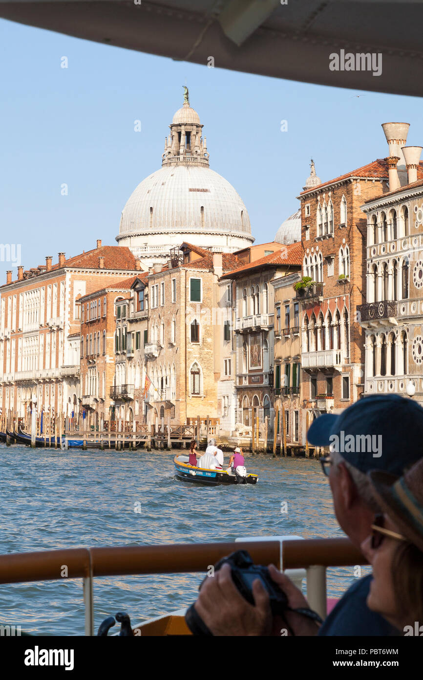 Travelling by Vaporetto public transport  Grand Canal, Venice, Veneto, Italy in a first person POV of Basilica di Santa Maria della Salute with touris Stock Photo