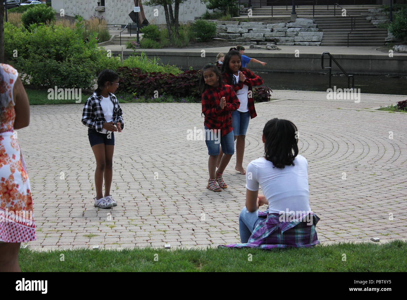 Local girls dancing in an outdoor theater in the park. Stock Photo