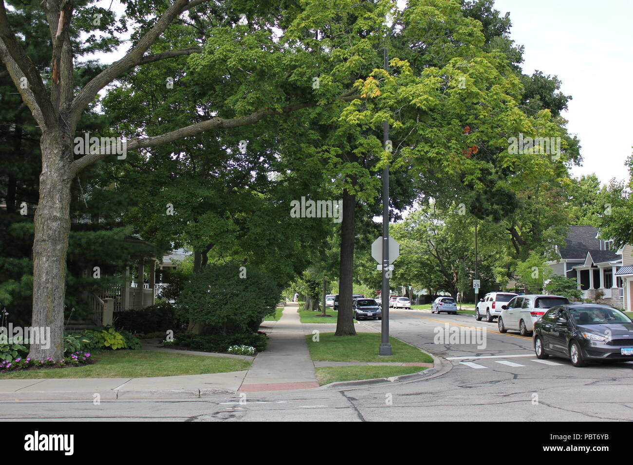 A typical streetscape with a street and quiet sidewalk in a small local town. Stock Photo