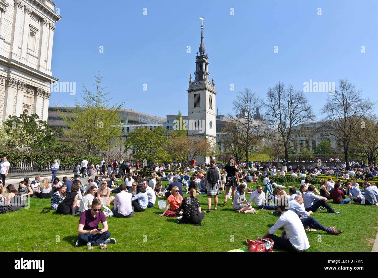 People gathered in a garden near St Paul's Cathedral to enjoy the hot British summer, London, England Stock Photo