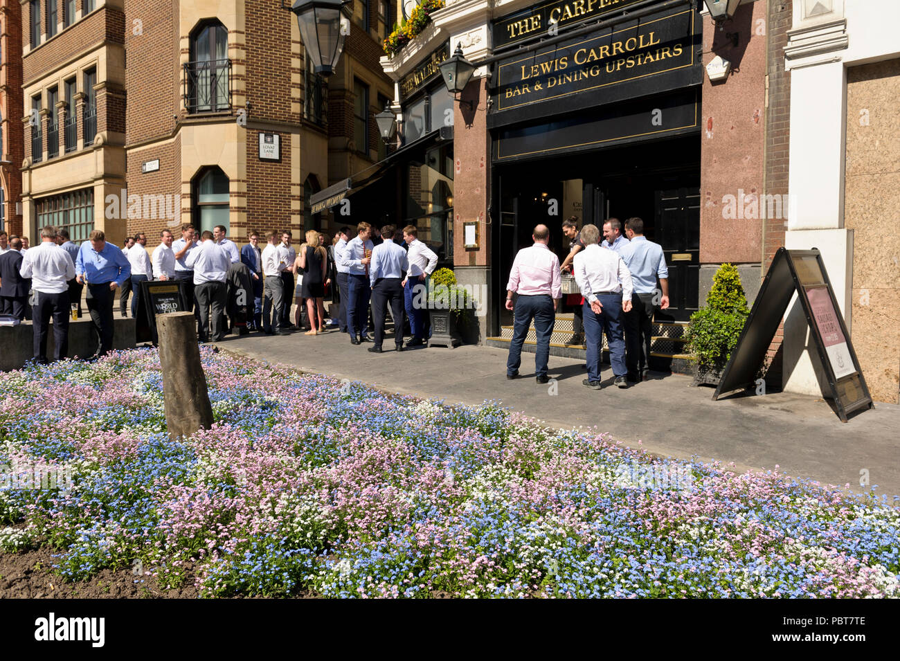 Groups of people standing, chatting and drinking outside a pub in London, England, United Kingdom Stock Photo